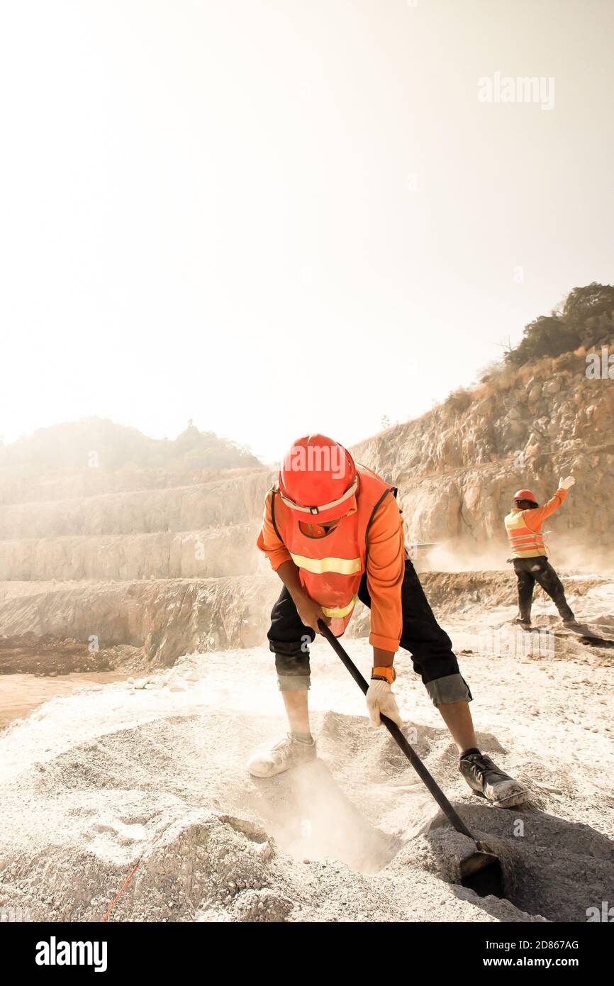 Miners working with mining tool in dusty and baking hot mining and