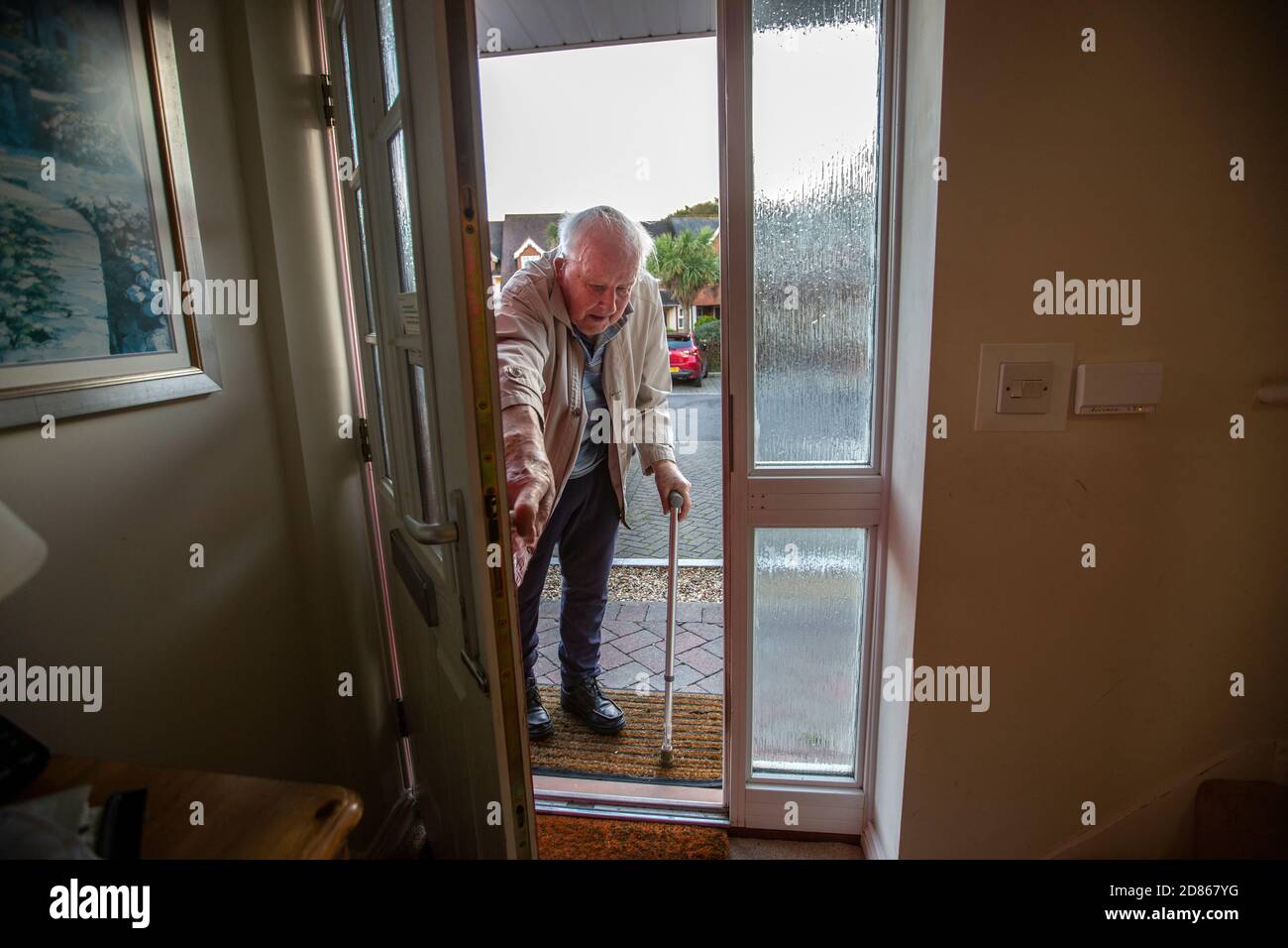 Elderly man in his 80's entering his home using a walking aid, Dorset, Southwest England, United Kingdom Stock Photo