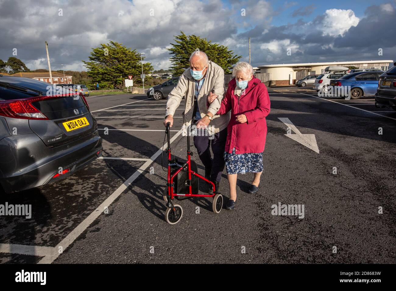 Elderly couple in their 80's wearing face masks, out on a sunny afternoon in Dorset, Southwest England, United Kingdom Stock Photo