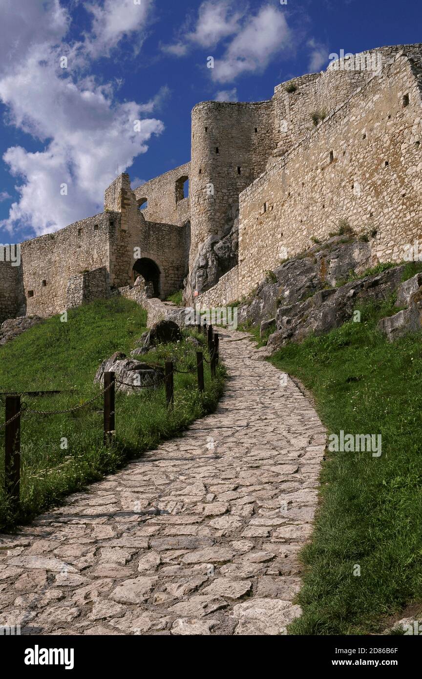 A paved path leads to the gateway of Spiš Castle (Spišský hrad), founded in the 1200s by Hungarian kings and now in the Košice Region of Slovakia.  It successfully repelled a Tartar siege in 1241 and grew to become Central Europe’s largest fortress complex.  Spiš was abandoned after a catastrophic fire in 1780, but a thorough restoration programme, launched in 1969, led to both the castle and its environs achieving UNESCO World Heritage Site status in 1993. Stock Photo