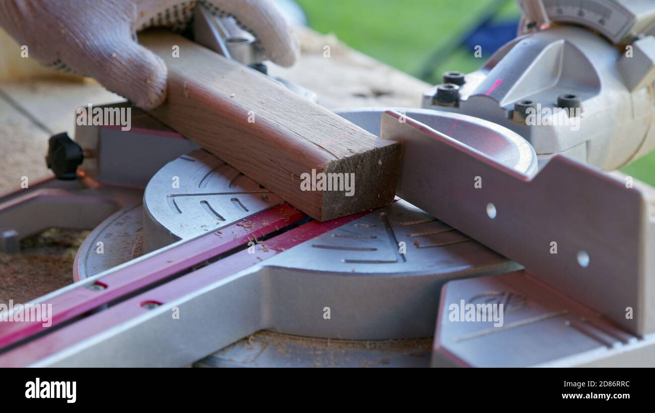 carpenter sets mitre saw angle 30 degrees and cuts wooden