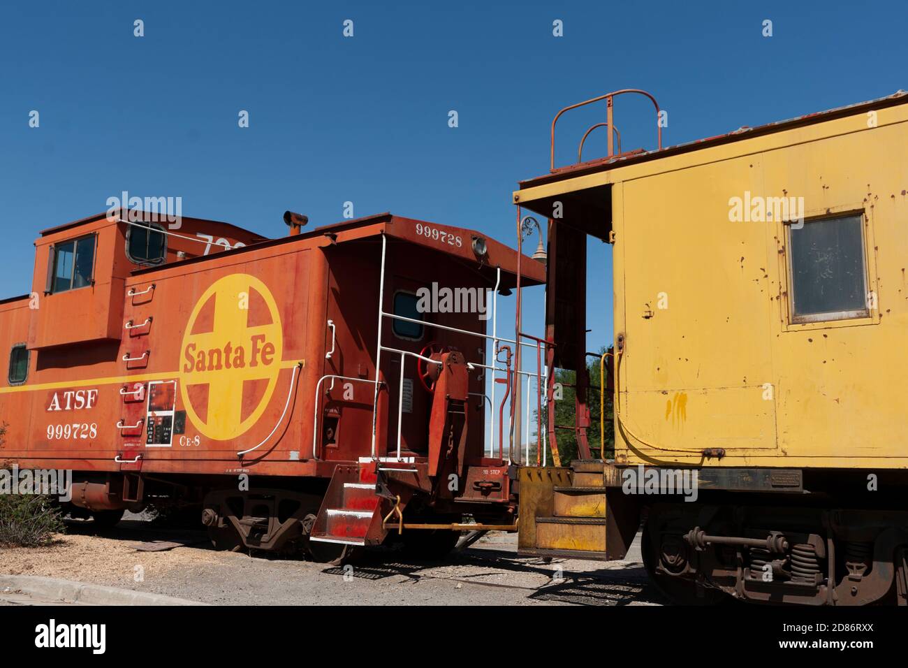 Barstow  USA   October 2 2015: Old bright orange and yellow colored Santa Fe train engine and carraige under blue sky. Stock Photo