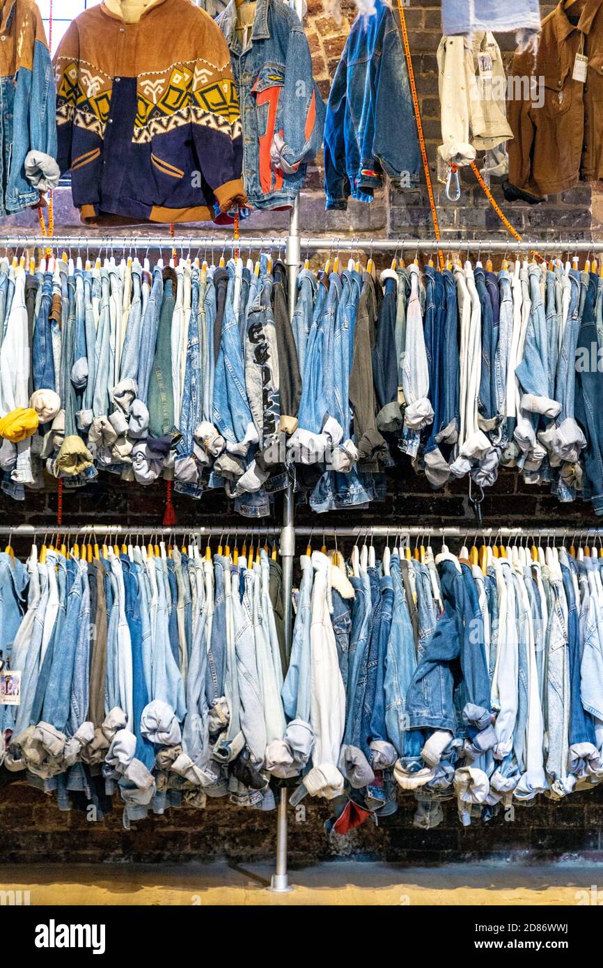 Rails with denim clothing inside Koo Style shop in Camden Stables Market, London, UK Stock Photo