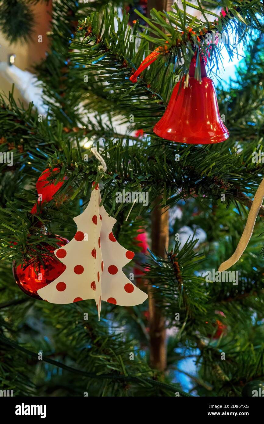 New years card with toys on herringbone, cardboard figure of Christmas tree and metal red bell hang on new year tree Stock Photo