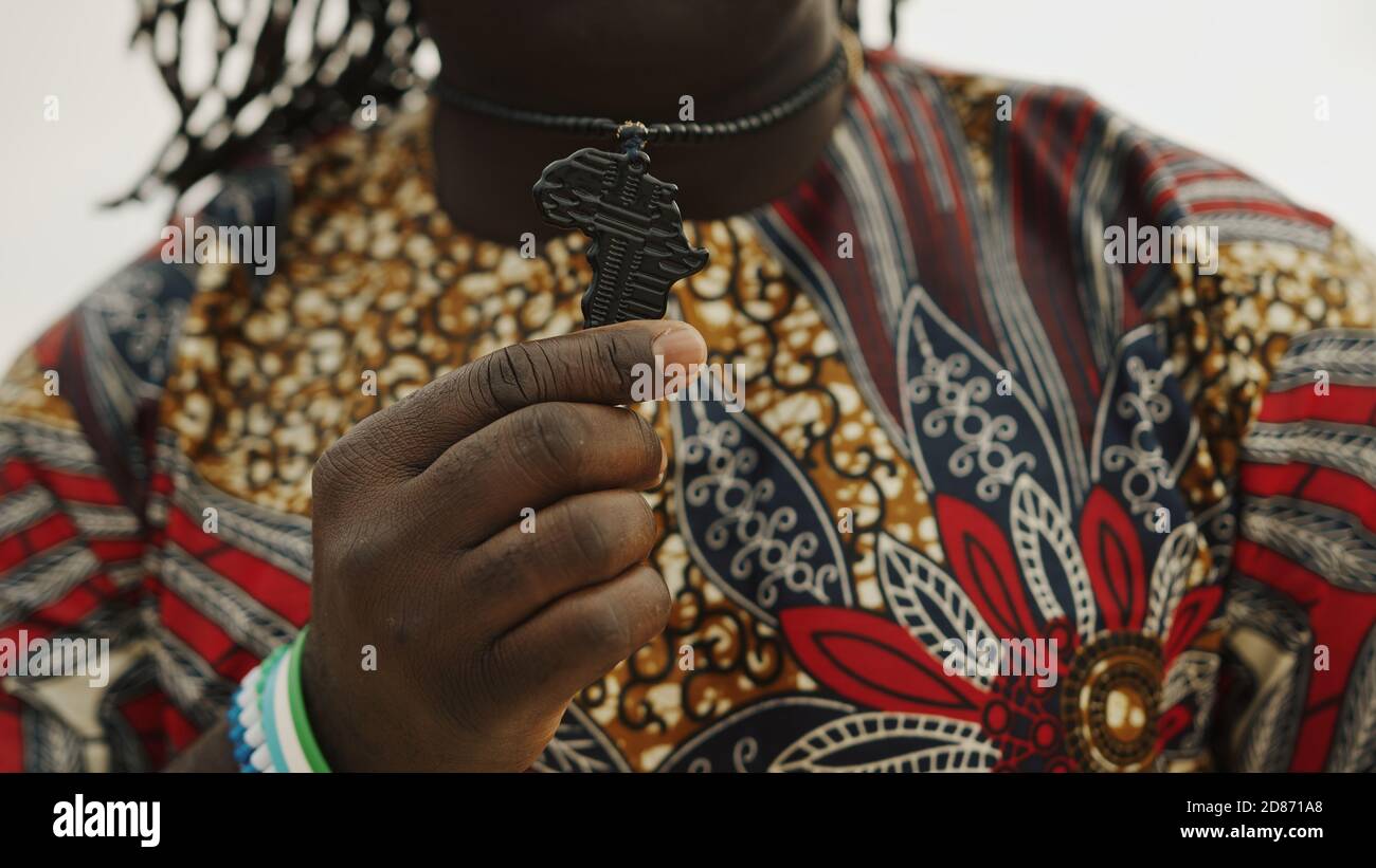 African man with traditional clothes showing neckchain pendant in the shape of africa. High quality photo Stock Photo