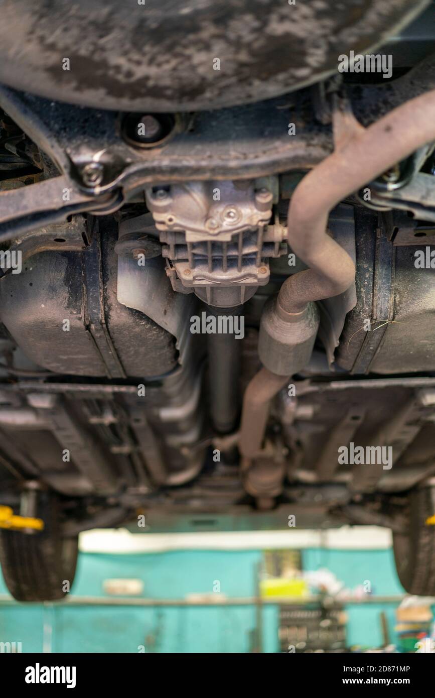 Car lifted in automobile service for fixing, worker repairs detail