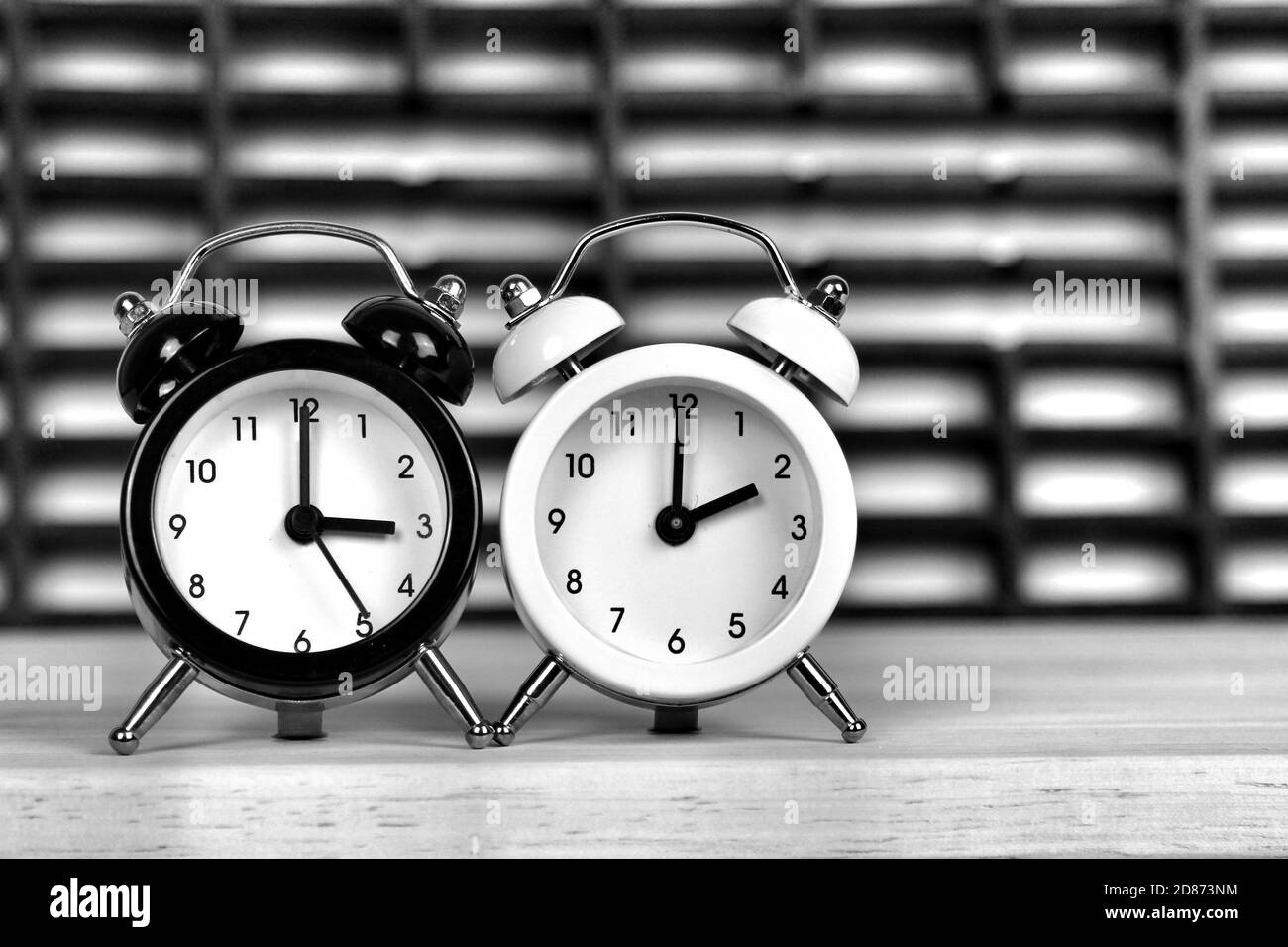 Clocks marking winter time change over checkered background Stock Photo