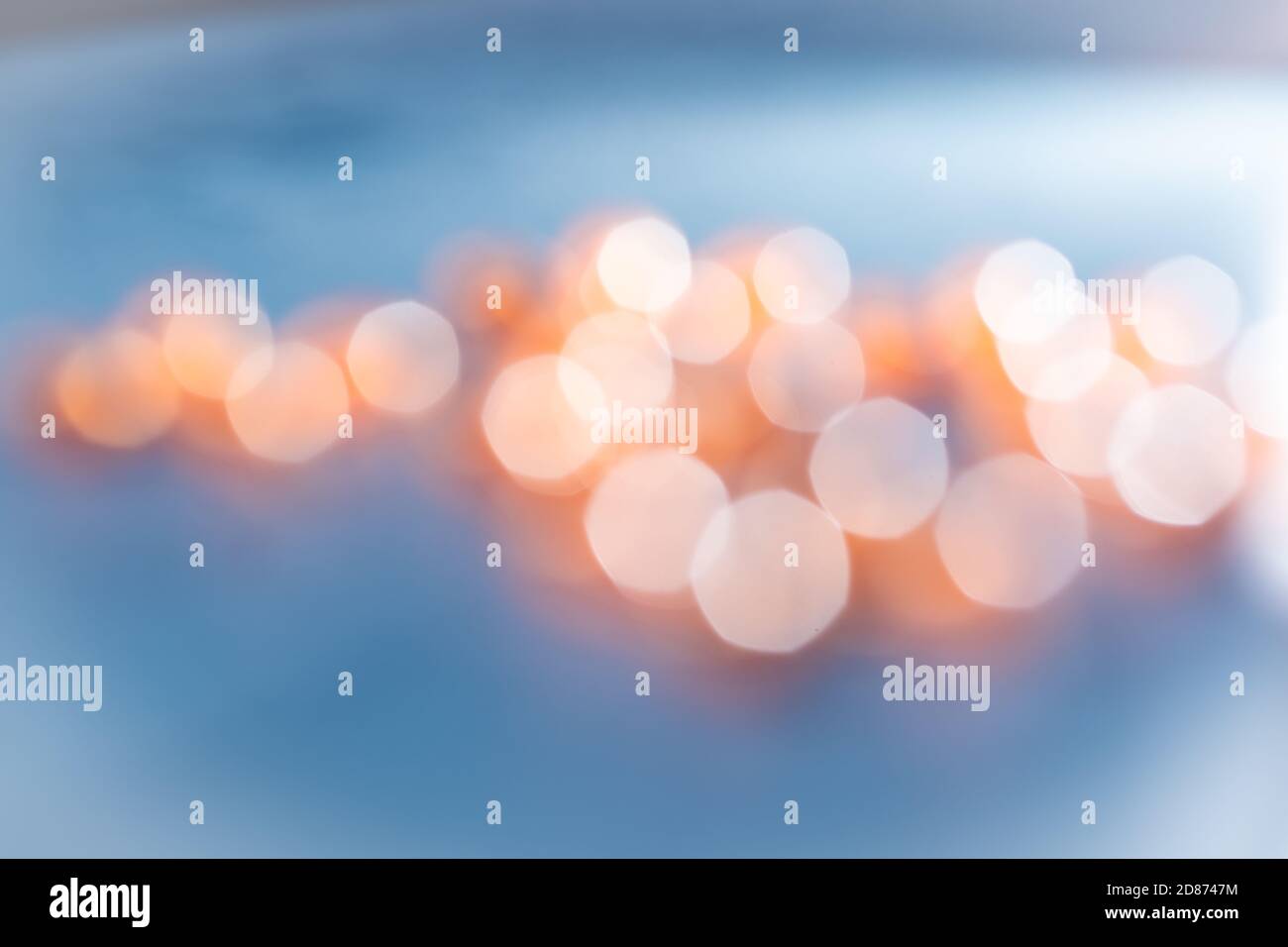 Minimalist and simple abstract blurred background in blue with orange lights bokeh Stock Photo