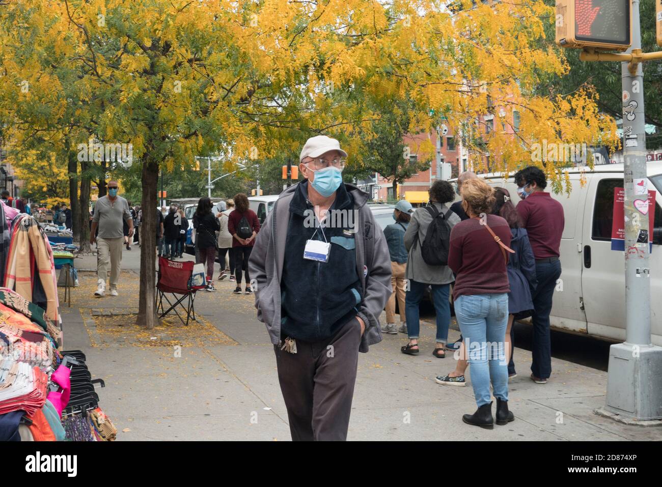 In Soho, Manhattan, New York, a poll worker walked along the line during early voting in the 2020 Presidential election to answer any questions. Stock Photo
