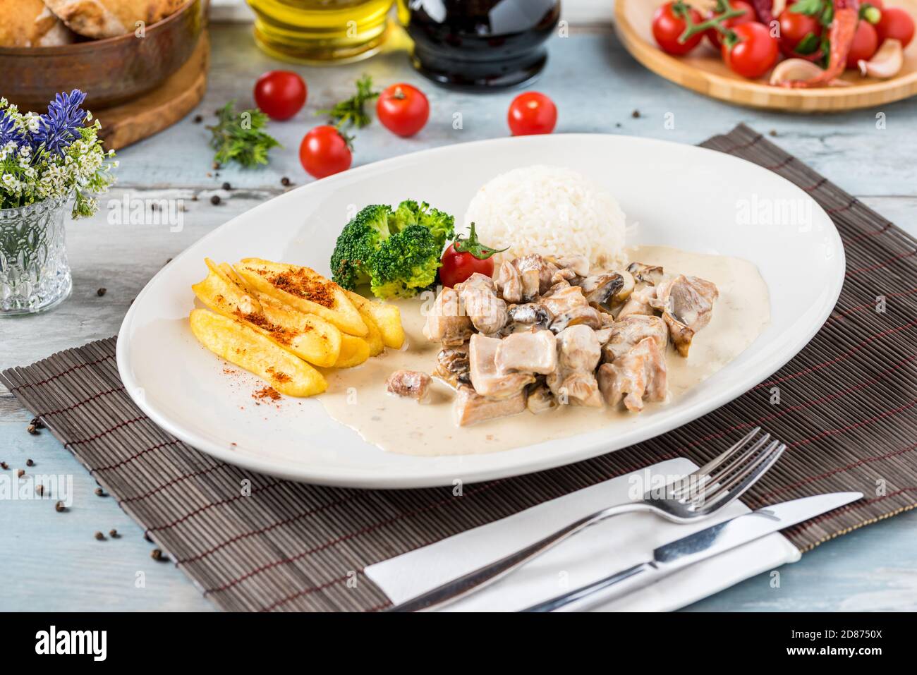 grilled chicken with rice and fried potatoes on white plate Stock Photo