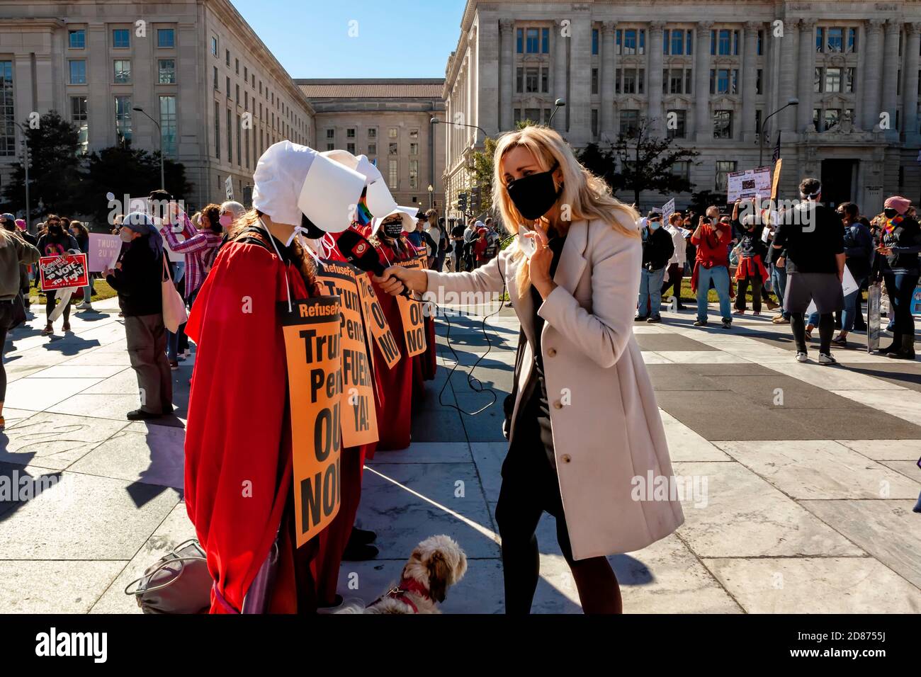 A reporter interviewing women dressed as handmaids at the Women's March in Freedom Plaza, Washington, DC, United States Stock Photo