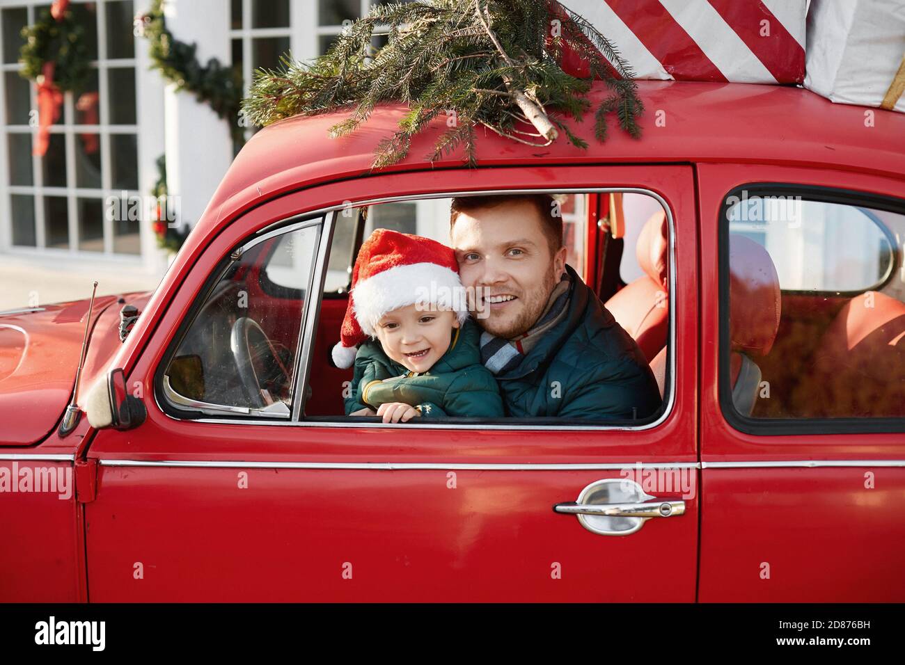Handsome Man With Cute Baby Boy In Santa Claus Hat Inside The Red Retro Car With Christmas Gifts Stock Photo Alamy