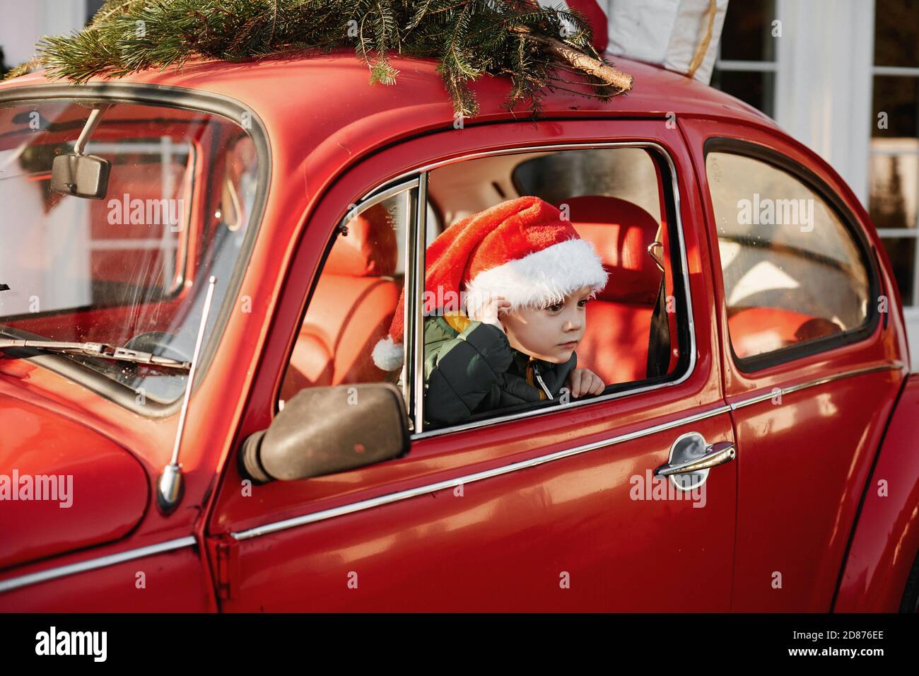 A Little Boy In A Santa Claus Hat Posing In A Red Retro Car With A Christmas Tree On The Roof Stock Photo Alamy
