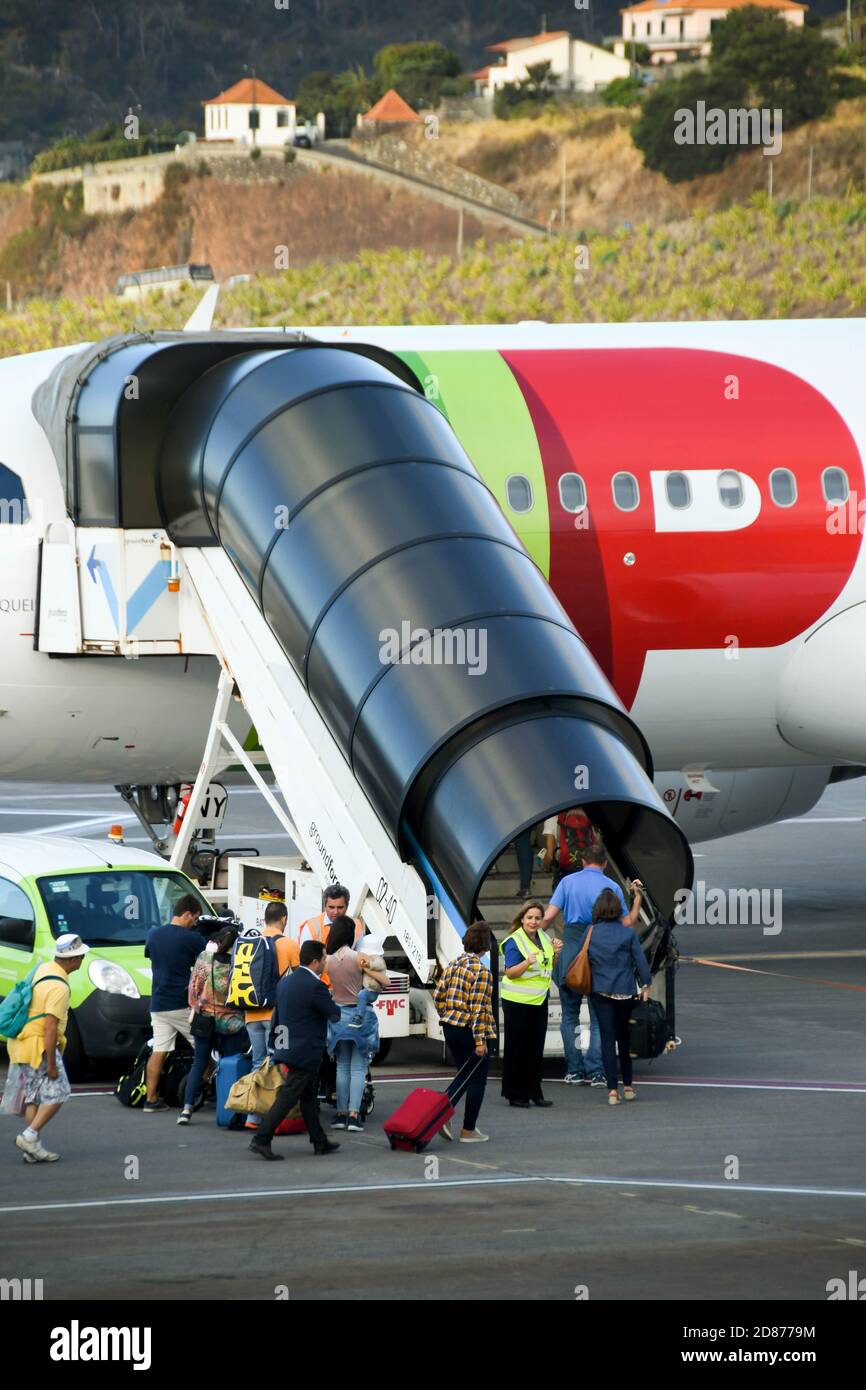 Funchal, Madeira, Portugal - October 2017: Passengers with luggage boarding an aircraft using a set of covered stairs Stock Photo