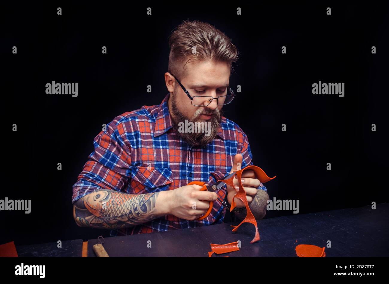 Man working with leather wording with leather goods in studio Stock Photo