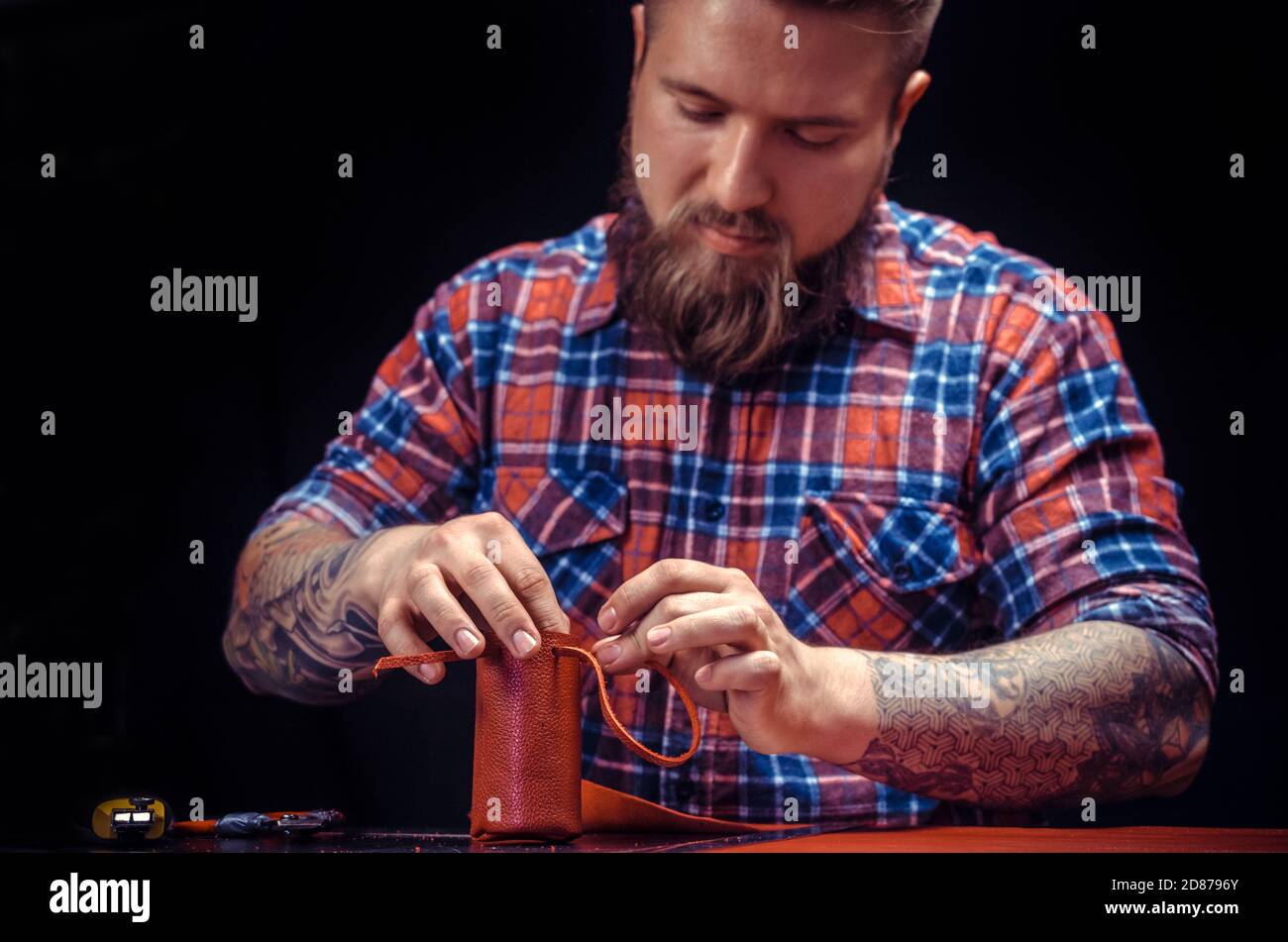Craftsman produces leather workpiece at the workplace Stock Photo