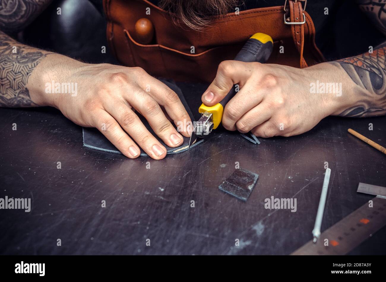 Leather cutter producing leather goods Stock Photo