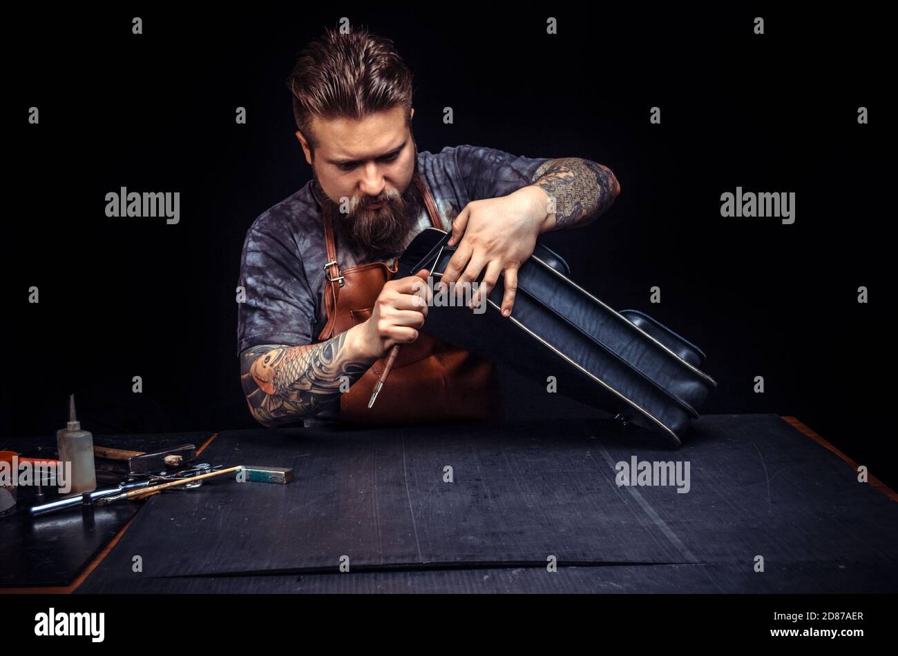 Craftsman working with leather processes a workpiece from leather Stock Photo