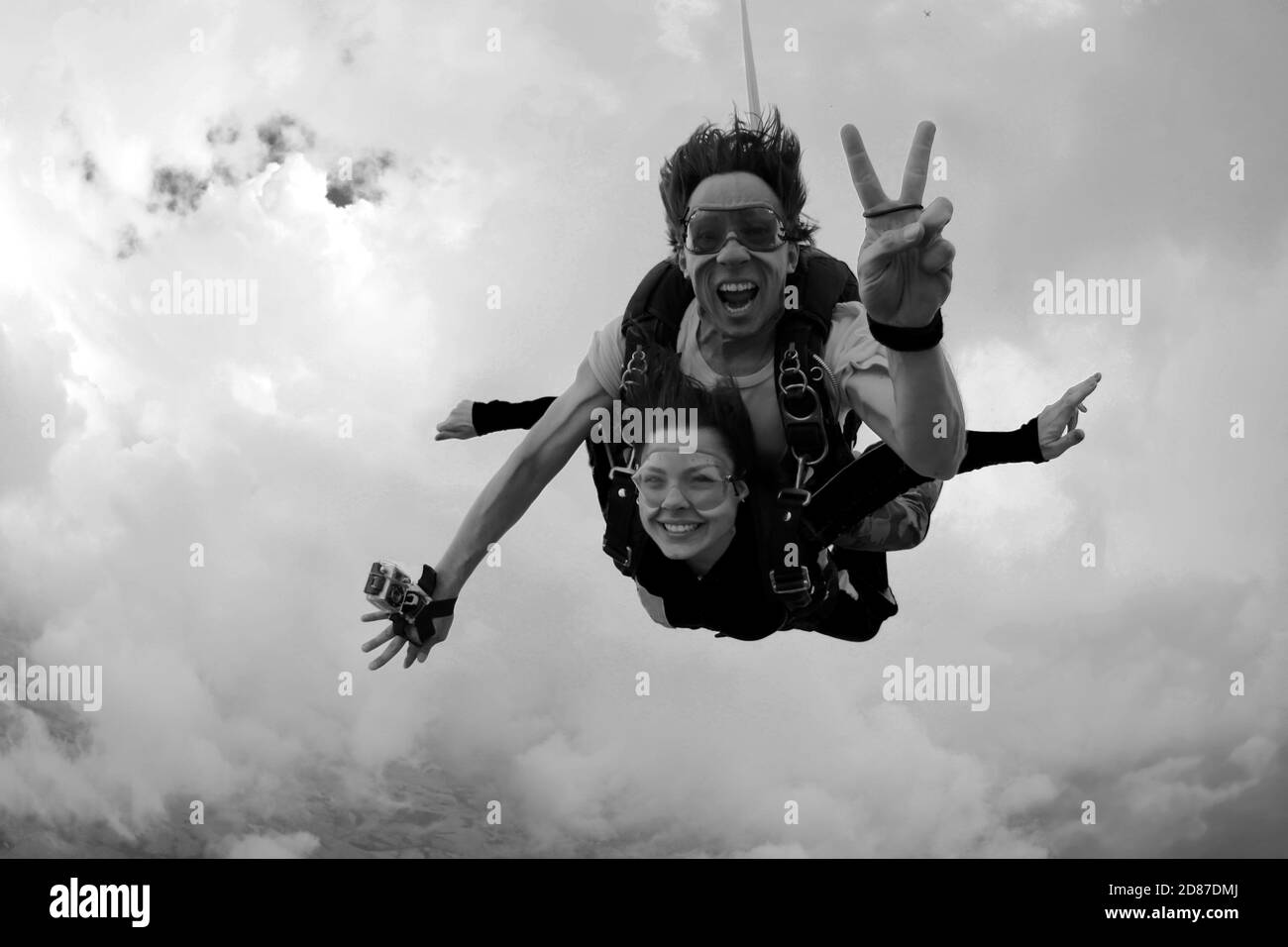 Skydiving tandem happiness on a cloudy day Black and white Stock Photo