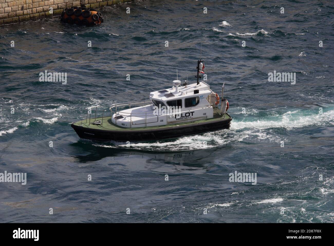 Gibraltar pilots boat underway pitching and yawing across swell caused by propeller wash of a cruise ship. Stock Photo