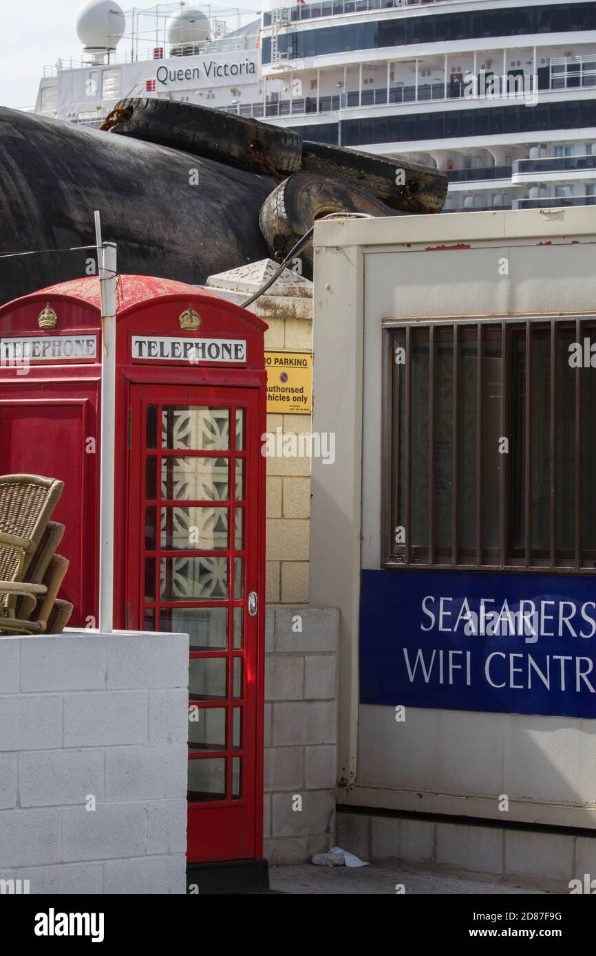 Old British red telephone box with Cunard cruise liner Queen Elizabeth in the background Stock Photo
