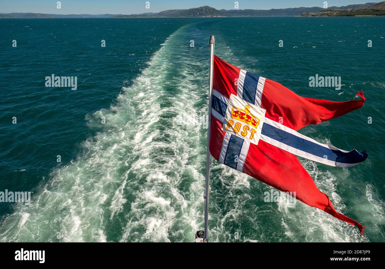 The post symbol on Norwegian flag of a Hurtigruten ship, foaming spray, Trondheimfjord, Agdenes, Trøndelag, Norway, Scandinavia, Europe, adventure tri Stock Photo
