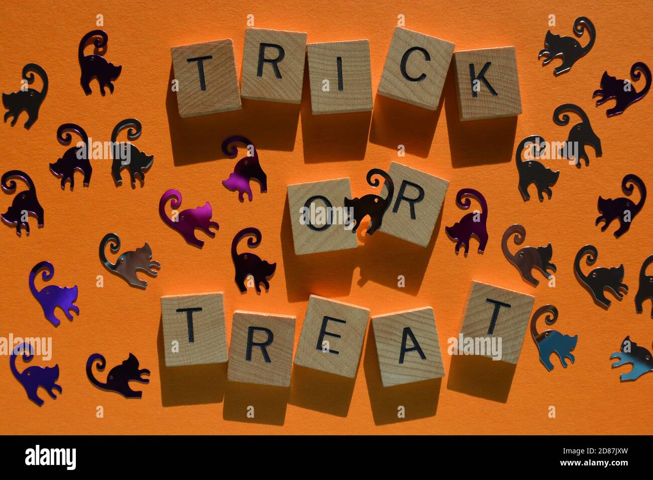 Trick or Treat in wood alphabet letters surround by Halloween themed cat shapes Stock Photo