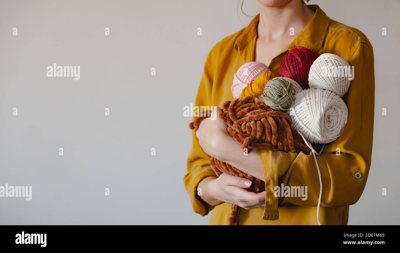 Rolls of cotton ropes in woman hand. Knitting, crocheting, handmade