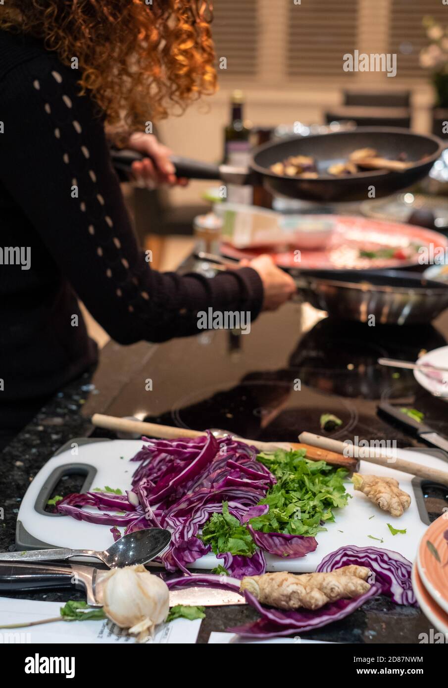 Preparing a vegan Asian Pad Thai stir fry with red cabbage, aubergine, tofu and noodles. Stock Photo