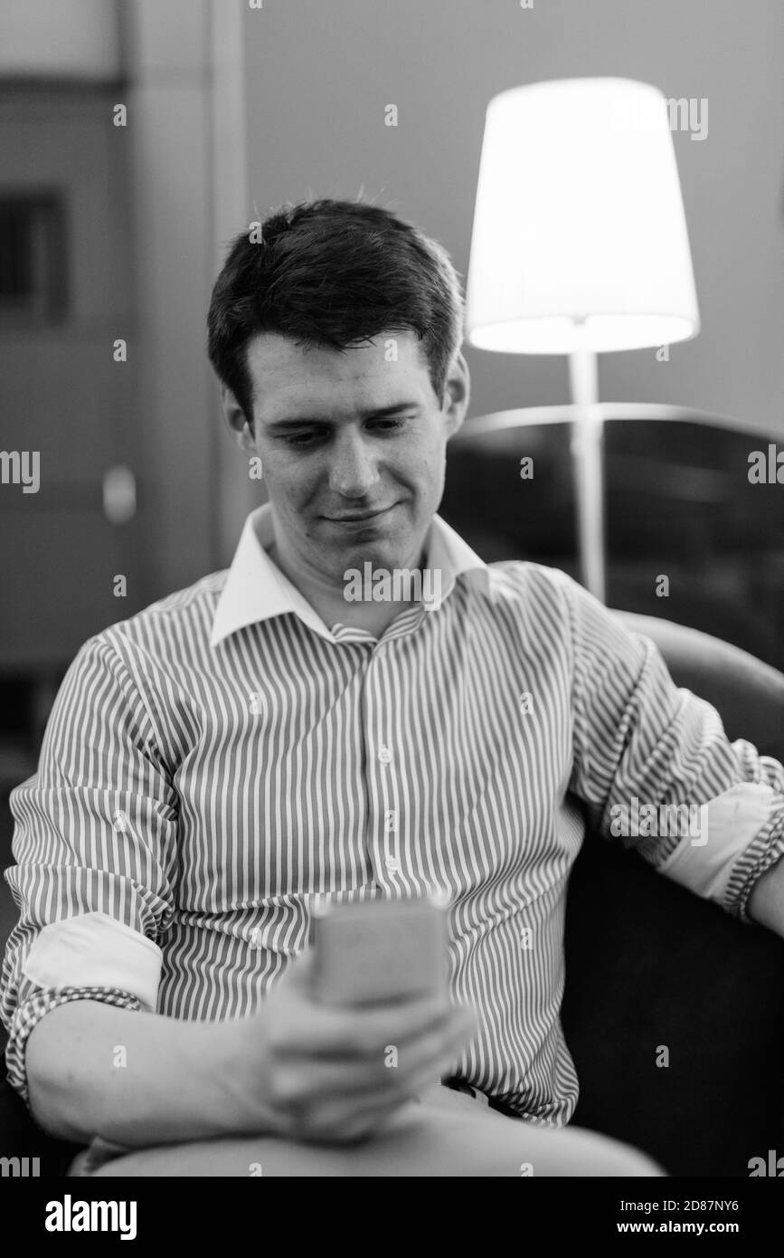 Young handsome businessman relaxing at the hotel lobby Stock Photo