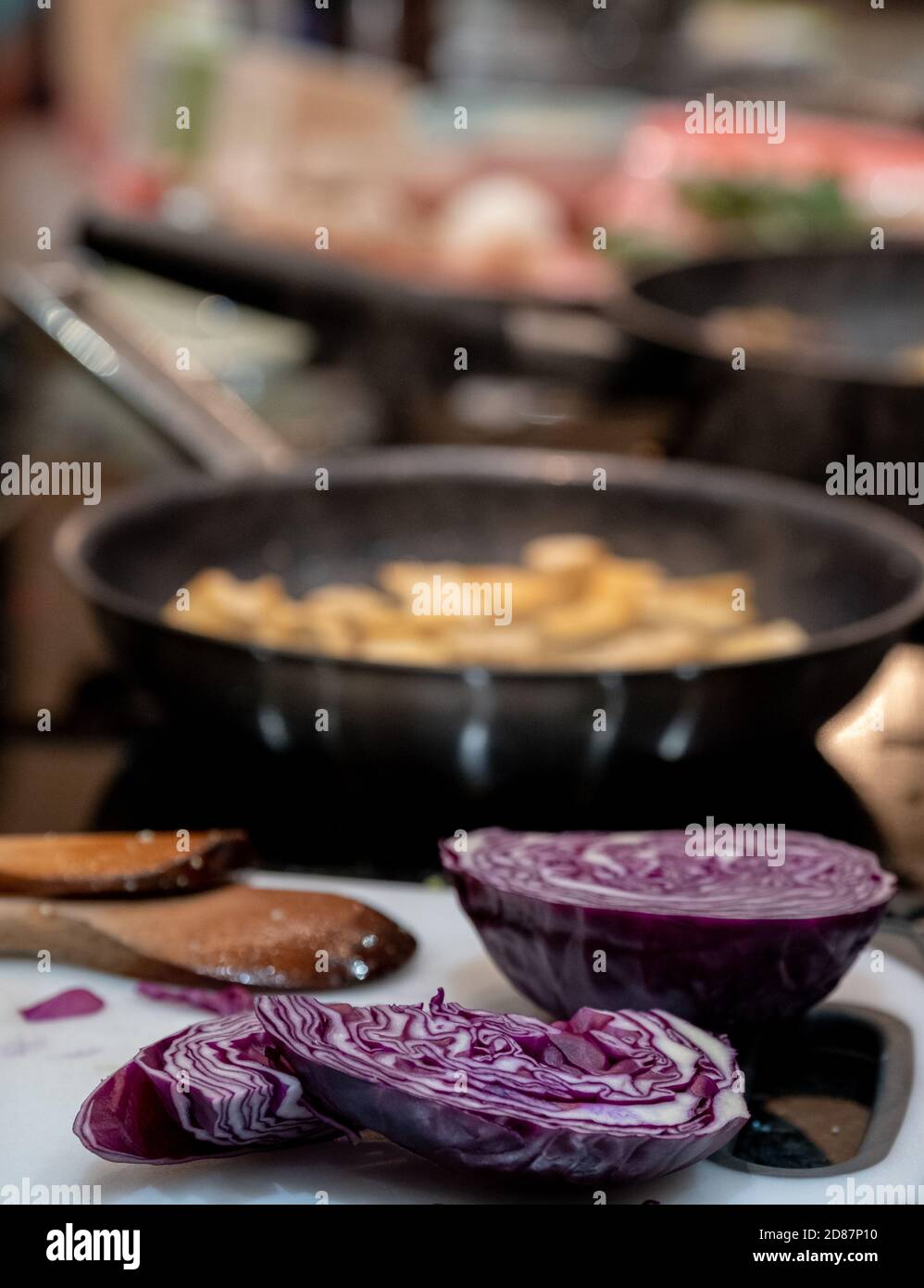 Preparing a vegan Asian Pad Thai stir fry with red cabbage, aubergine, tofu and noodles. Stock Photo