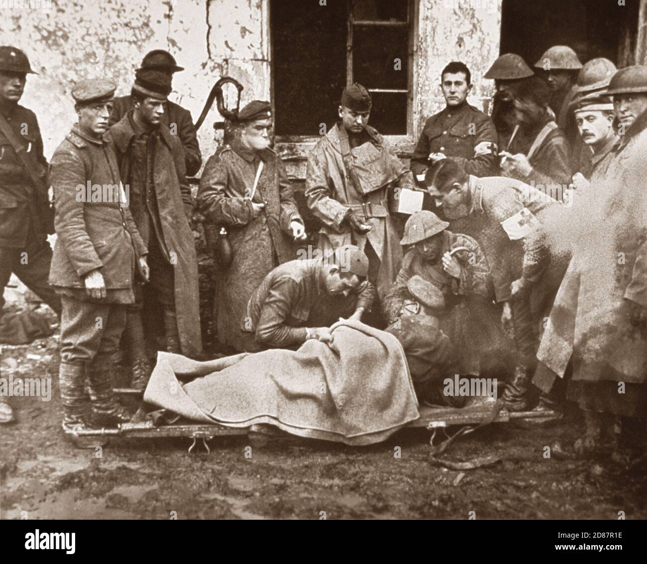 Lieutenant C.S. Darley, a Catholic chaplain, treating German officer lying on Stretcher outside Building, 89th Division Dressing Station, near Remonville, France, U.S. Army Signal Corps, November 2, 1918 Stock Photo