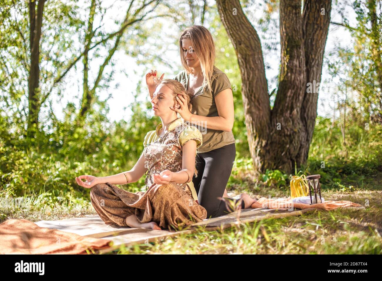 Massage expert provides a thorough massage outside. Stock Photo