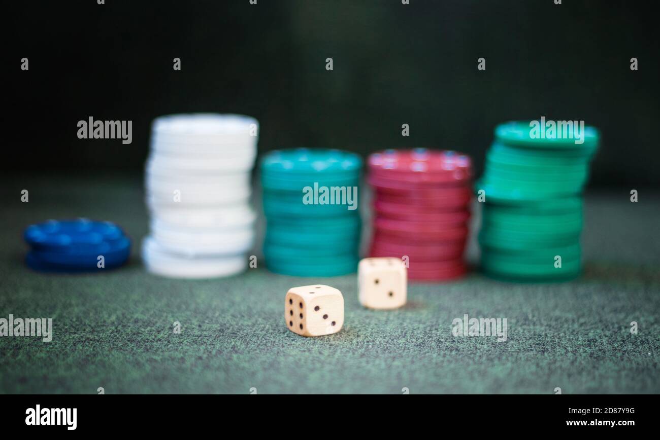 Casino poker chips stack dice on green felt background Stock Photo