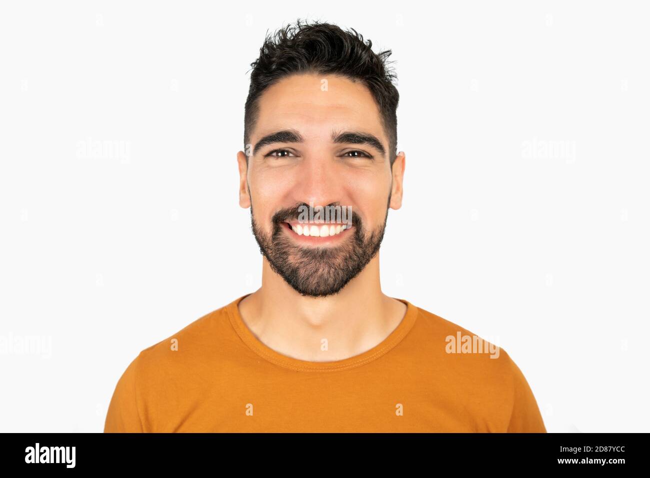Portrait of young happy man smiling against white background in studio ...