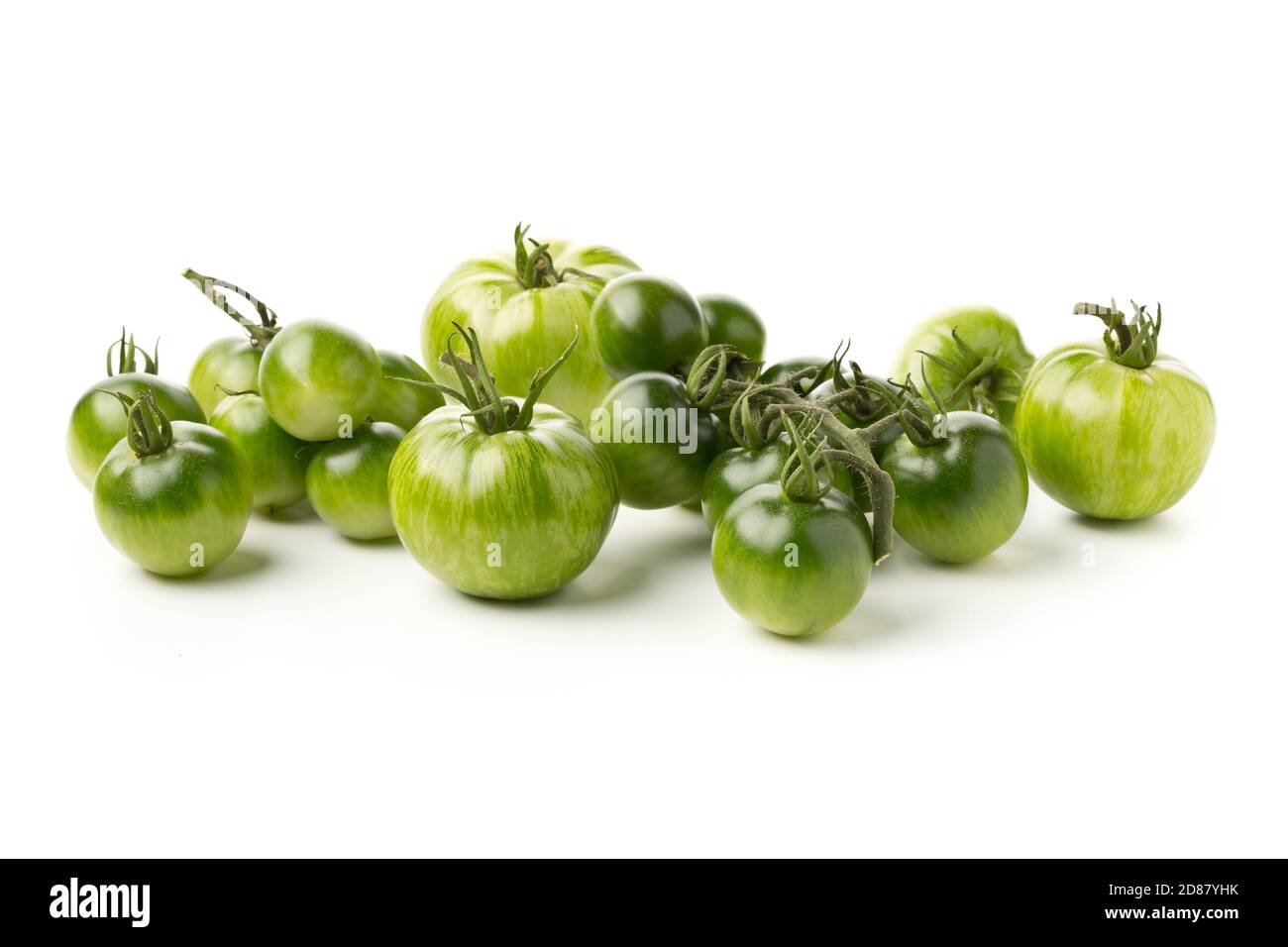 Heap of unripe green tomatoes over white background, unripe tomatoes can be fried or used for relish, selective focus Stock Photo
