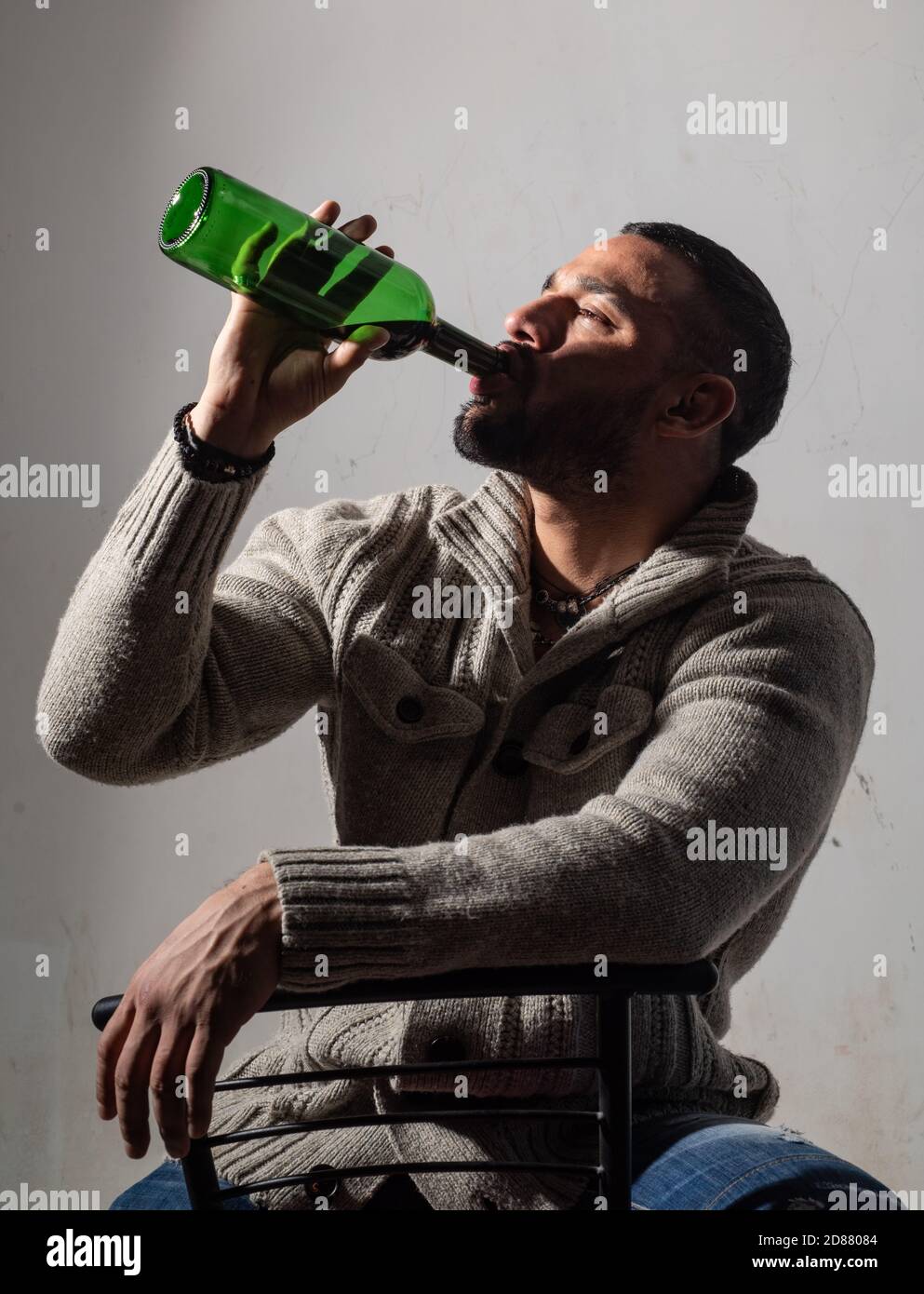 Drunk man drinking wine. Depressed guy with bottle alcohol. Abuse in addiction and alcoholism problem. Stock Photo