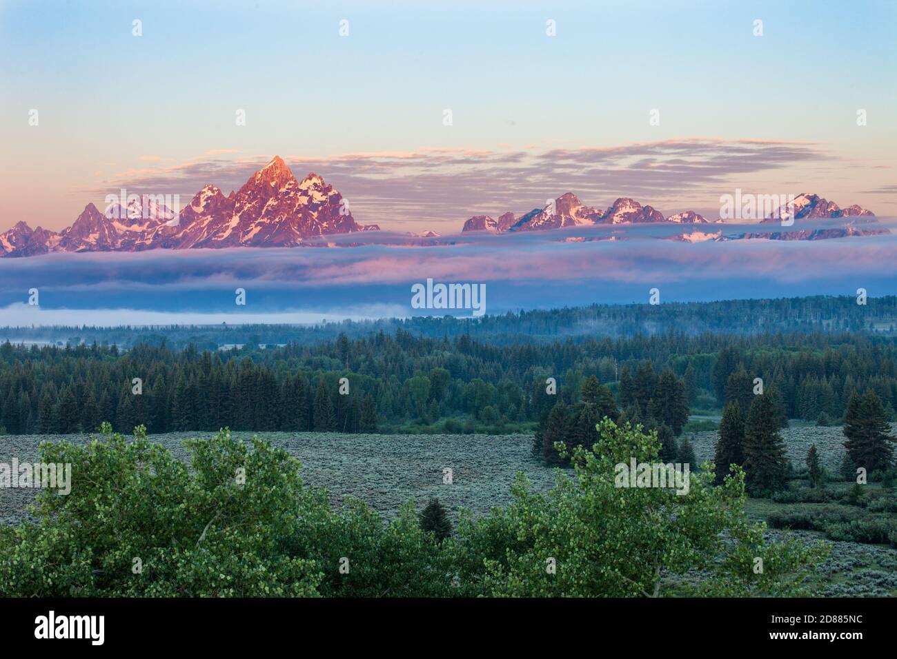 Grand Teton and the Teton Range with low clouds at sunrise in Grand Teton National Park in Wyoming, USA. Stock Photo