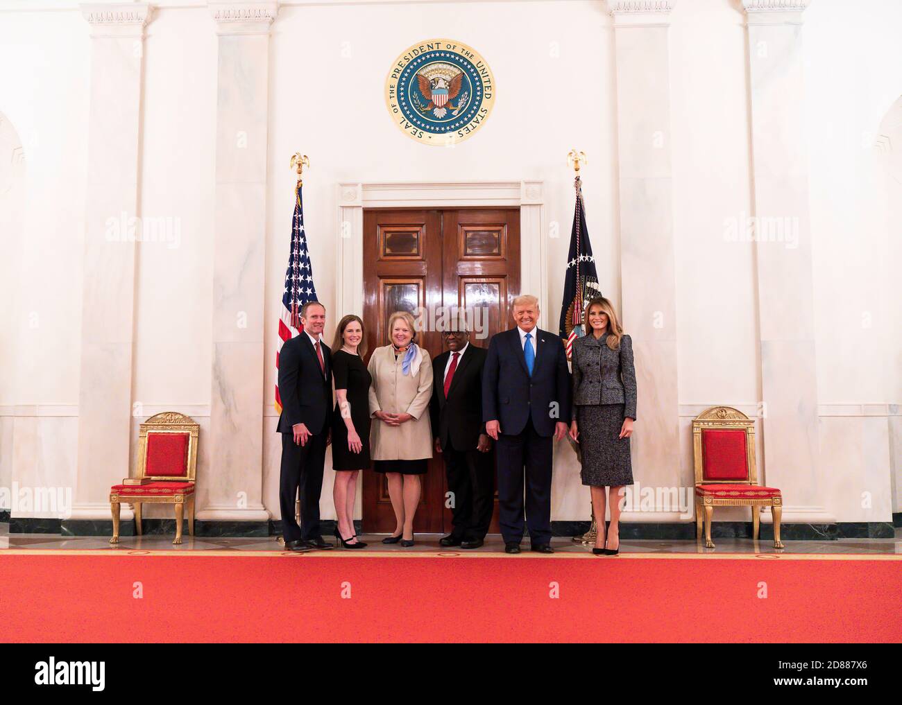 President Donald J. Trump and First Lady Melania Trump pose for a photo with Supreme Court Associate Justice Amy Coney Barrett, her husband Jesse Barrett, Supreme Court Associate Justice Clarence Thomas, and his wife Virginia Thomas in the Cross Hall of the White House Monday, Oct. 26, 2020, after attending Barrett’s swearing-in ceremony as Supreme Court Associate Justice. Stock Photo