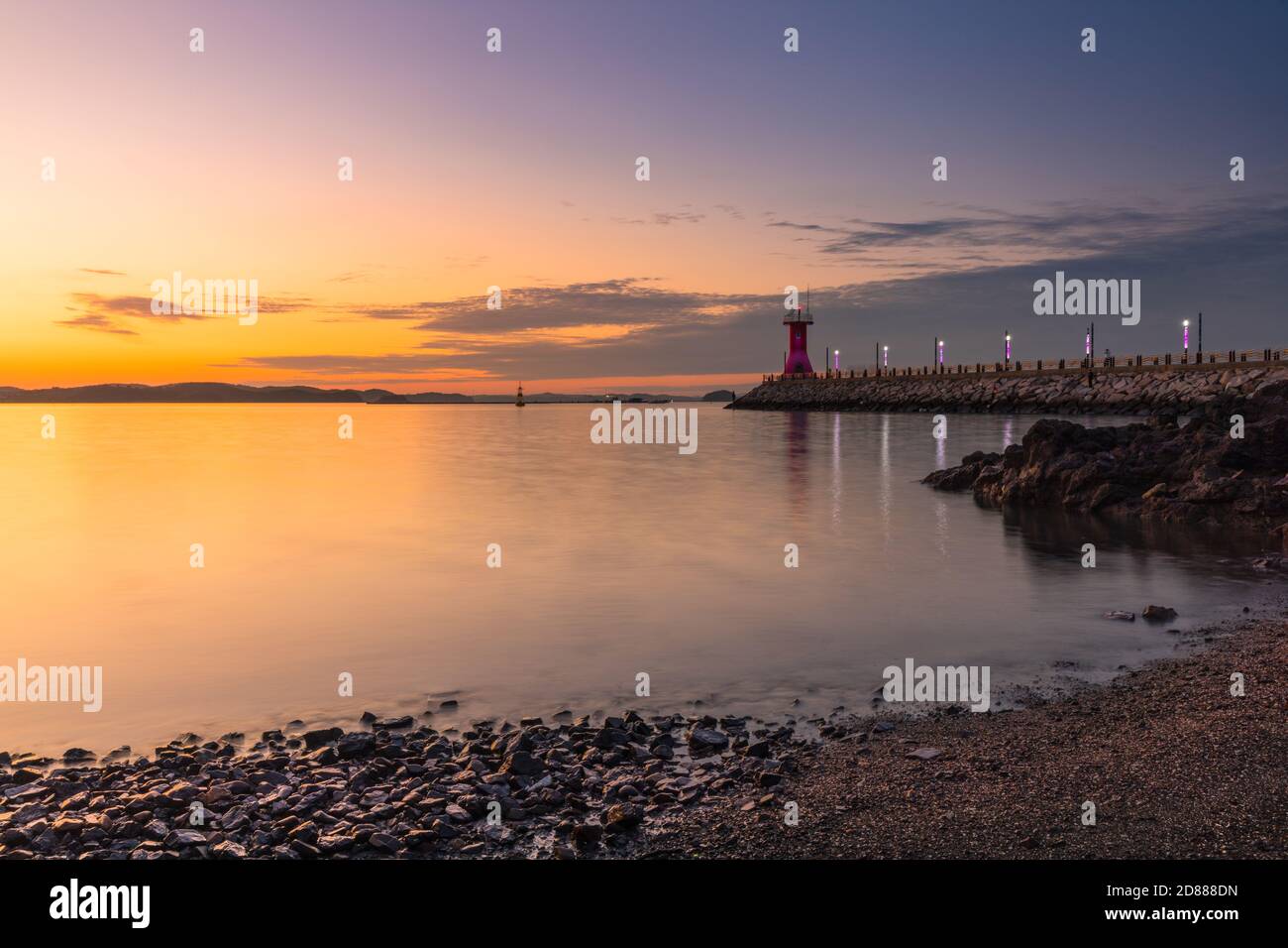 Sunset seascape, lighthouse over breakwater. Seosan-si, Chungcheongnam-do, Republic of Korea. Stock Photo