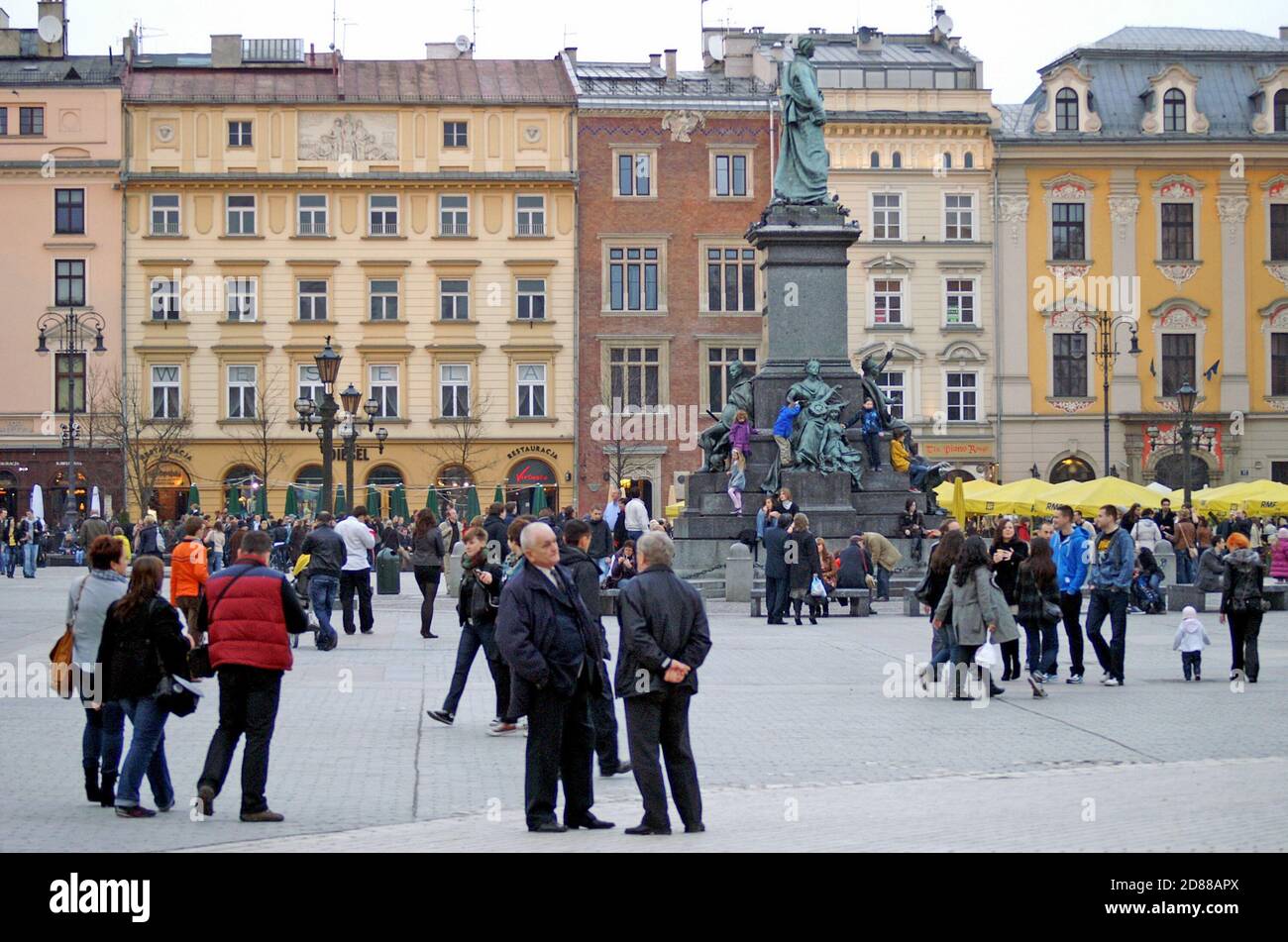 Historic townhouses offer a backdrop for the cultural social space of Krakow Square in the Old town of Krakow, Poland. Stock Photo