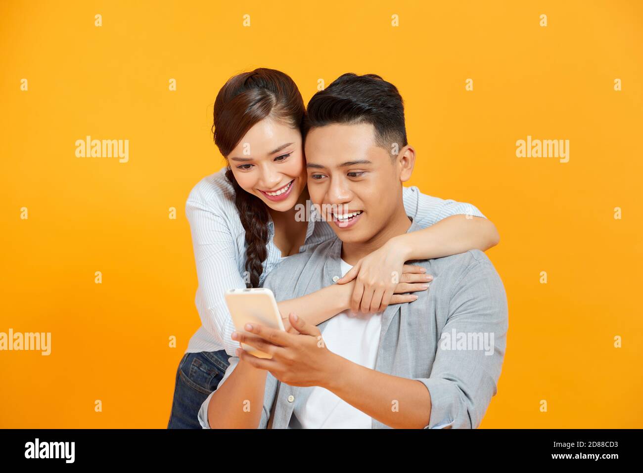 Couple or friends laughing funny and having fun with a smart phone Stock Photo