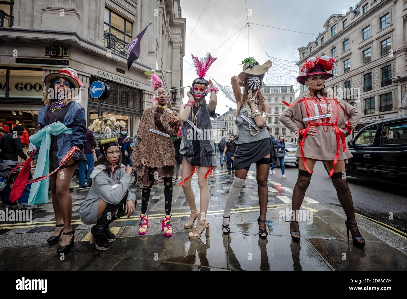 Models take part in a colourful flashmob street fashion show near Savile Row for designer Pierre Garroudi. London, UK. Stock Photo