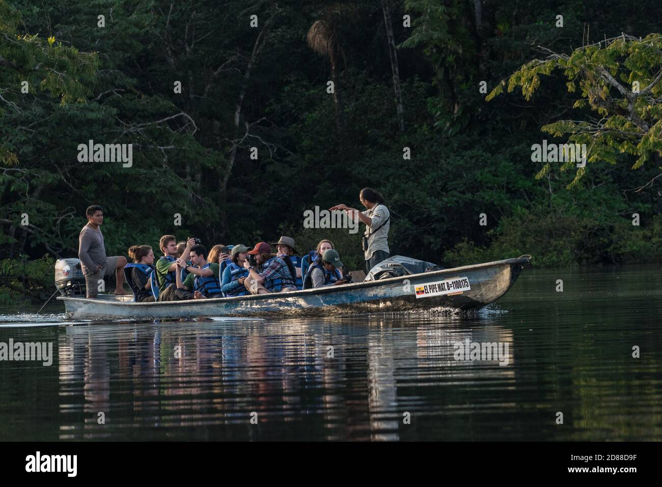 A boat full of ecotourists and their Ecuadorian guides in Cuyabeno wildlife reserve in Ecuador. Stock Photo