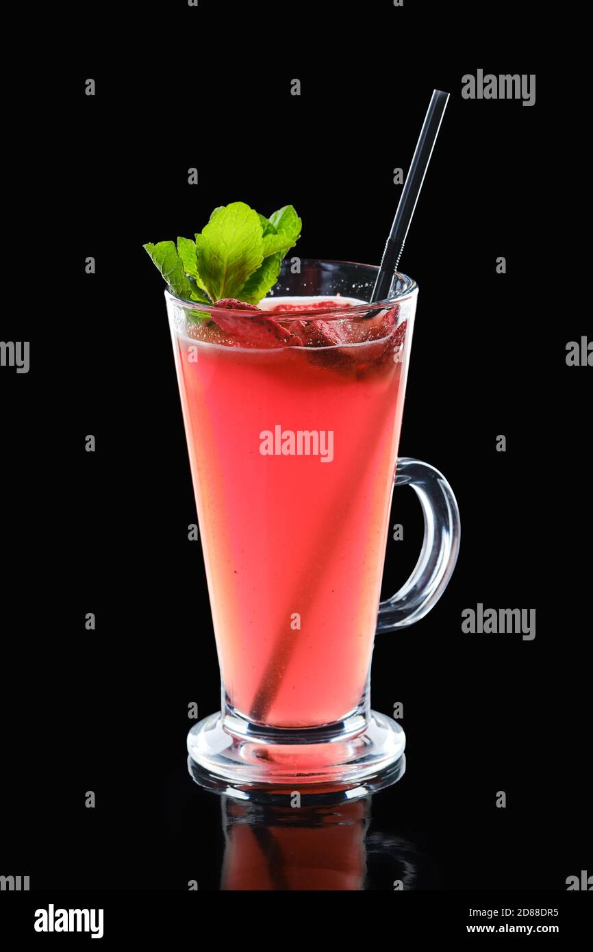 Glass of strawberry and mint hot drink isolated on black background