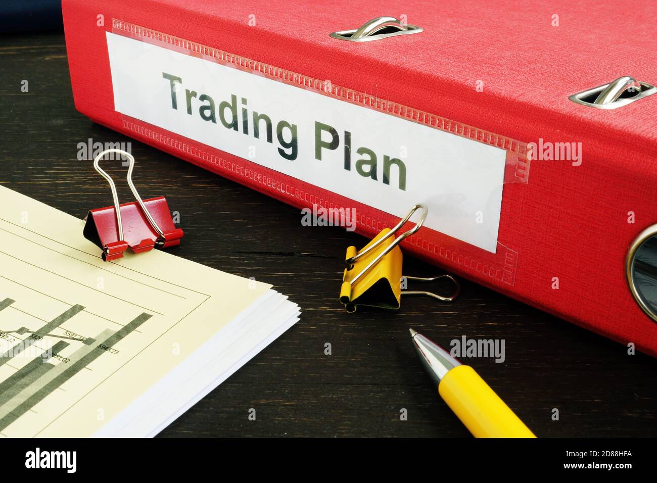 Trading plan and stack of papers with graphs. Stock Photo