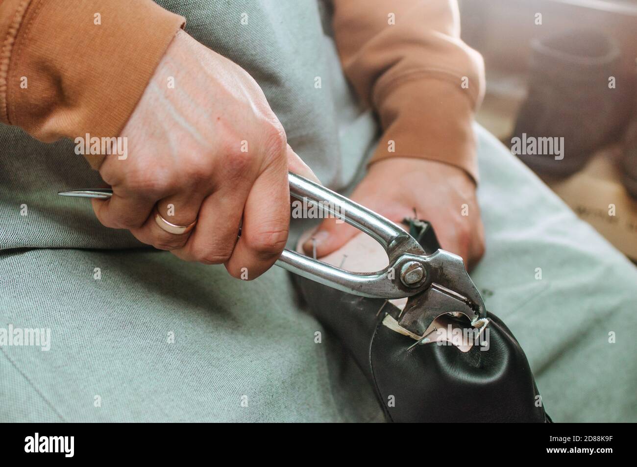 Shoemakers hands making shoe using special tools Stock Photo
