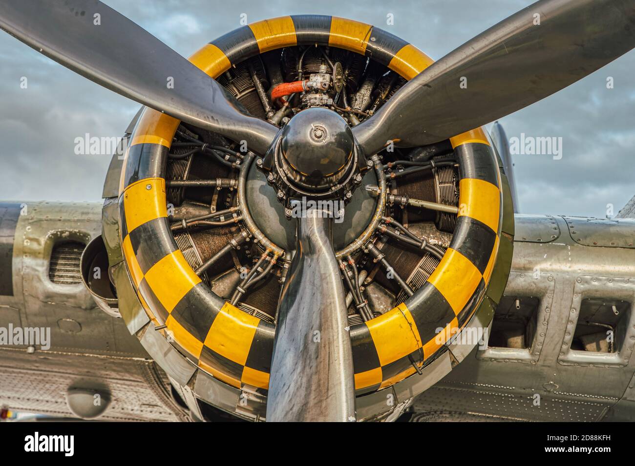 9 cylinder combustion engine with yellow, black square pattern. Nine chamber, air cooled radial motor with propeller closeup on heavy military bomber Stock Photo