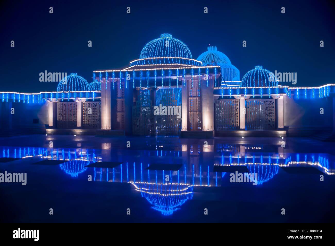 Night view of Kashiram memorial illuminated in blue light and reflections in polished floor surface, Lucknow,India Stock Photo