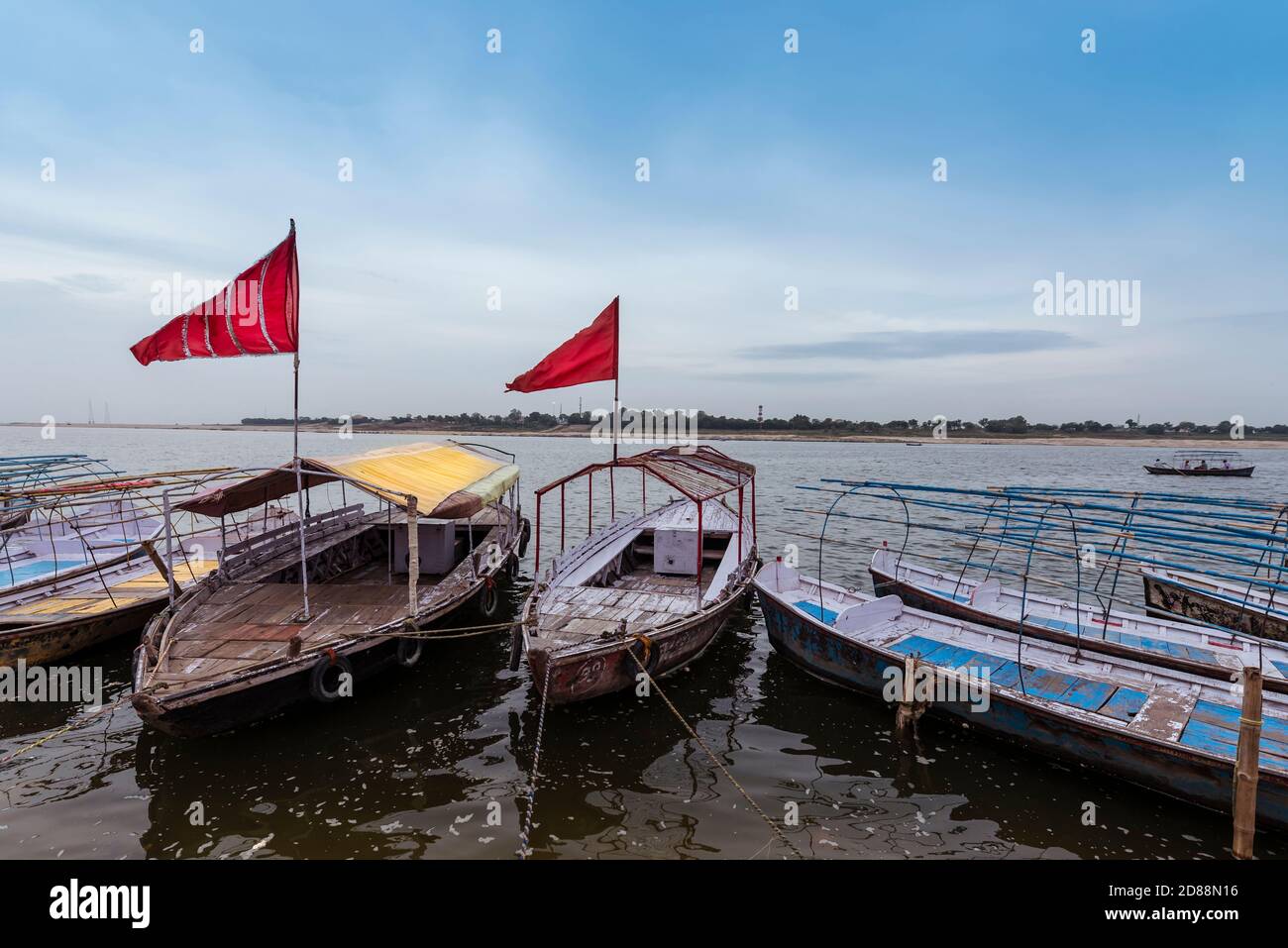 Boats with reflags on the banks of river Ganges waiting for devotees to ferry to Sangam,Prayagraj,India Stock Photo
